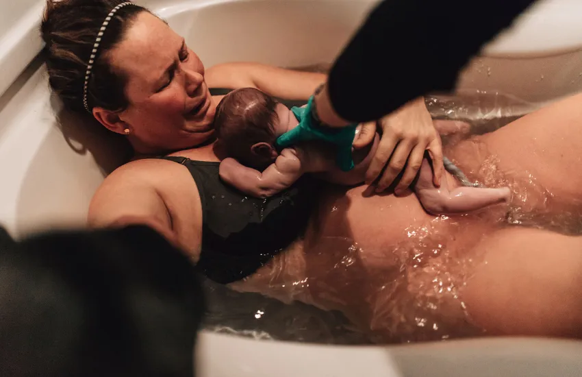 Image of a mother and baby skin to skin after baby is born in the water during a doula supported birth. Image represents birth doula services in the Twin Cities of Minneapolis and Saint Paul, Minnesota.