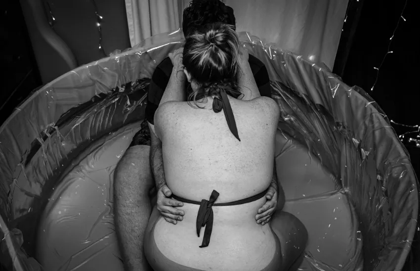 Birthing person and partner with a doula supported waterbirth. Image for testimonial from Minenapolis, Minnesota.