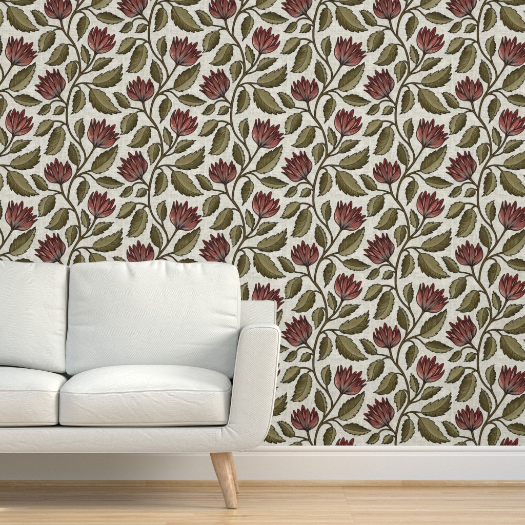 Hand-drawn red floral vine wallpaper with olive green leaves on a cream grasscloth texture, shown behind a white sofa in a living room.
