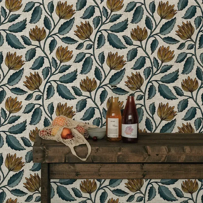 Vintage botanical wallpaper with ochre blooms, muted teal foliage, and a cream textured ground used as a rustic kitchen accent wall.