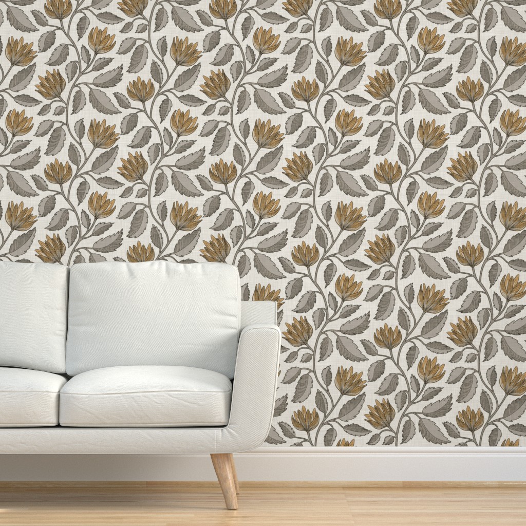 Hand drawn botanical floral vine in gray and ochre on textured grasscloth wallpaper behind a cream sofa in a living room.