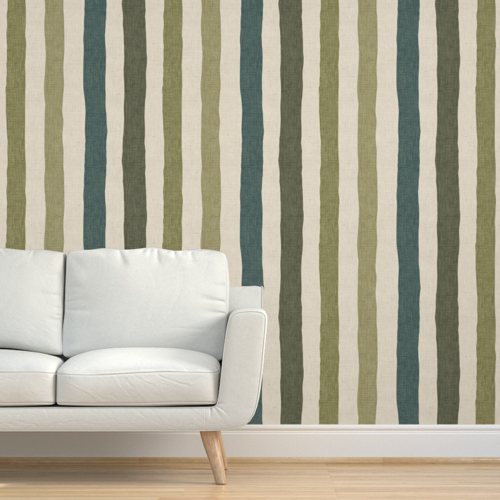 Muted olive, sage, teal, and cream linen-look stripe wallpaper used as a living room feature wall behind a white sofa.