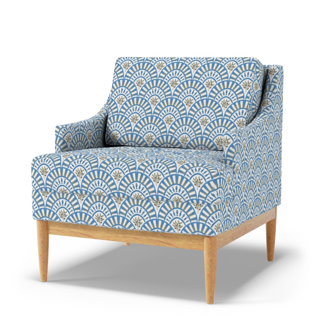 Blue and white Art Deco fan arch print with olive botanical sprigs on an upholstered armchair with natural wood legs.
