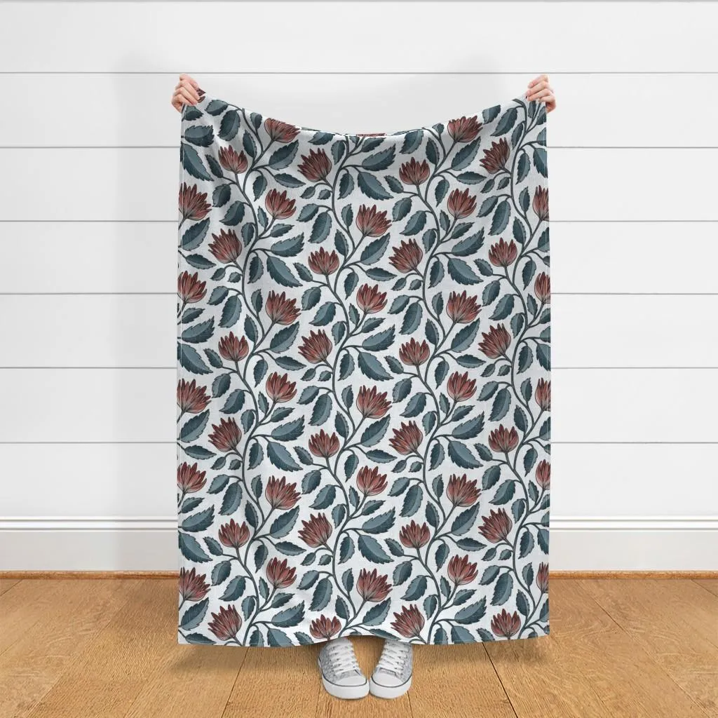 Hand drawn floral vine in muted rust and blue green, shown on fabric for scale in a neutral interior mockup with wood floor.
