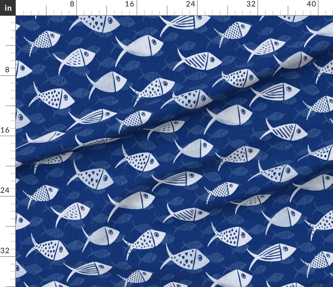 Navy Nautical School of Fish shown on draped fabric with white hand-drawn fish and tonal blue fish in the background.