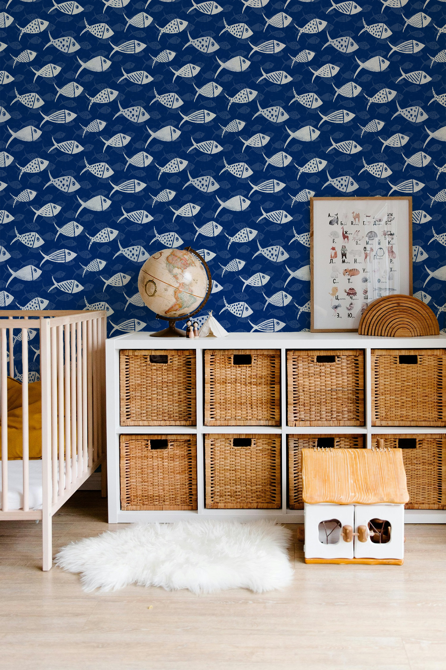 Navy Nautical School of Fish wallpaper in a nursery with white crib, globe and woven storage baskets.