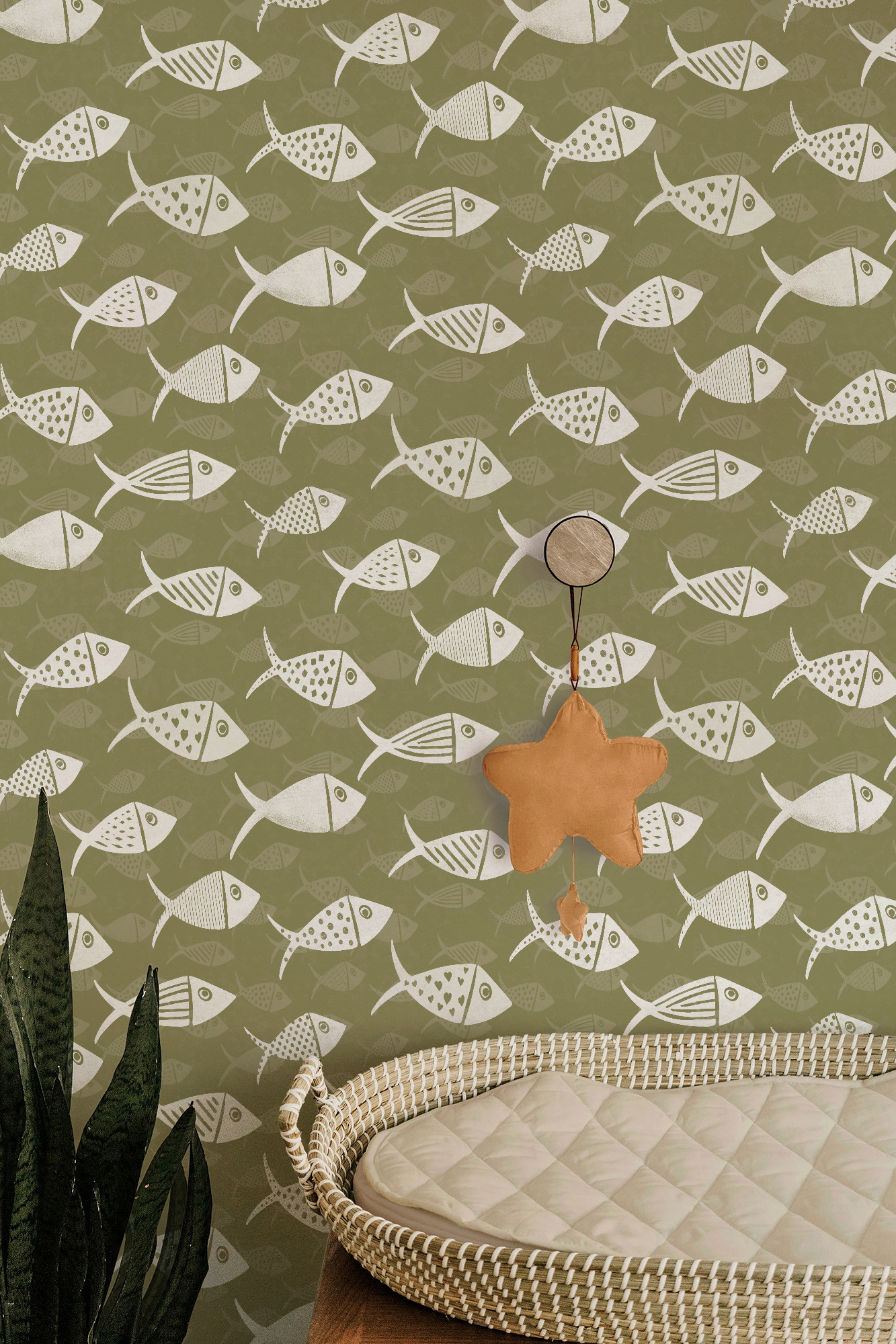 Olive green Nautical School of Fish wallpaper in a nursery with white fish, tonal fish silhouettes and a hanging star decoration.