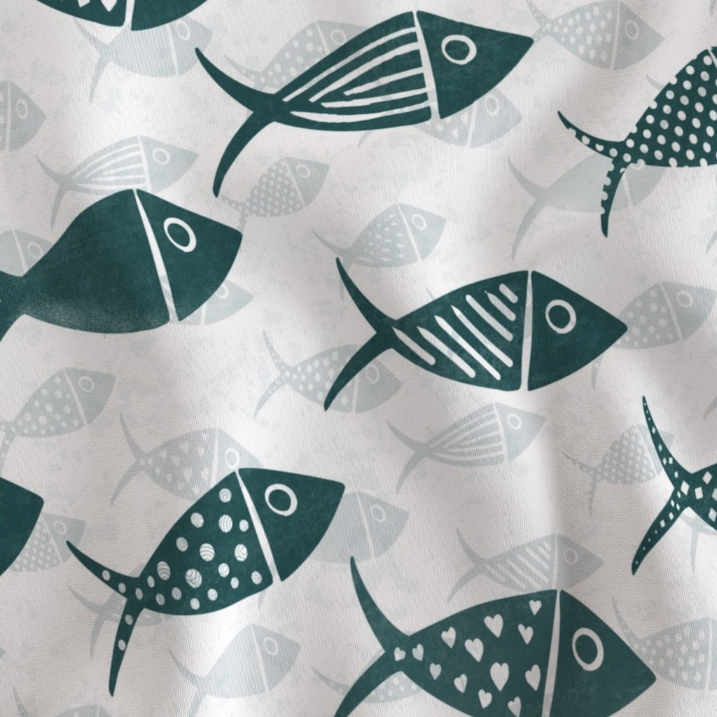 Close-up of teal and white Nautical School of Fish on fabric with striped, dotted and geometric fish over pale silhouettes.
