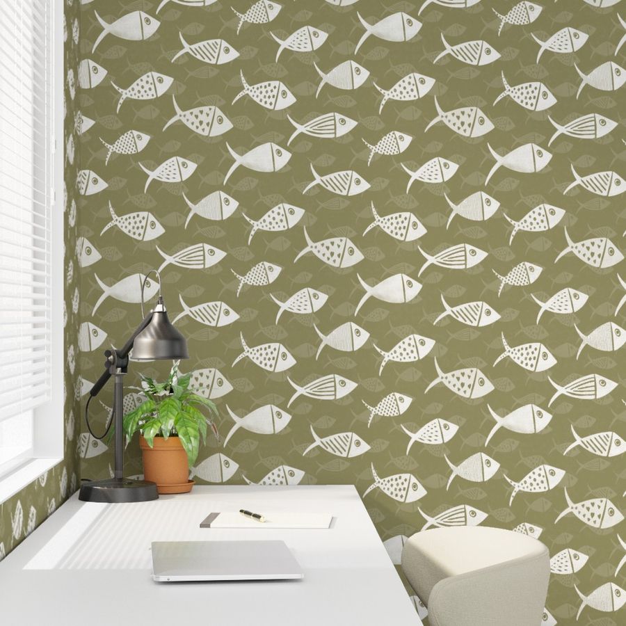 Olive green Nautical School of Fish wallpaper in a bedroom with white hand-drawn fish, bedside lamp and small potted plant.