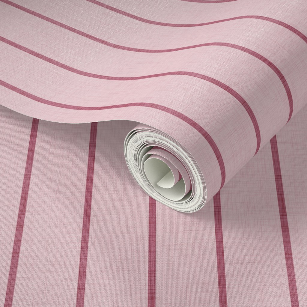 Pale pink Roselk Design wallpaper with narrow dusty rose stripes, shown rolled to reveal the subtle linen-look texture.
