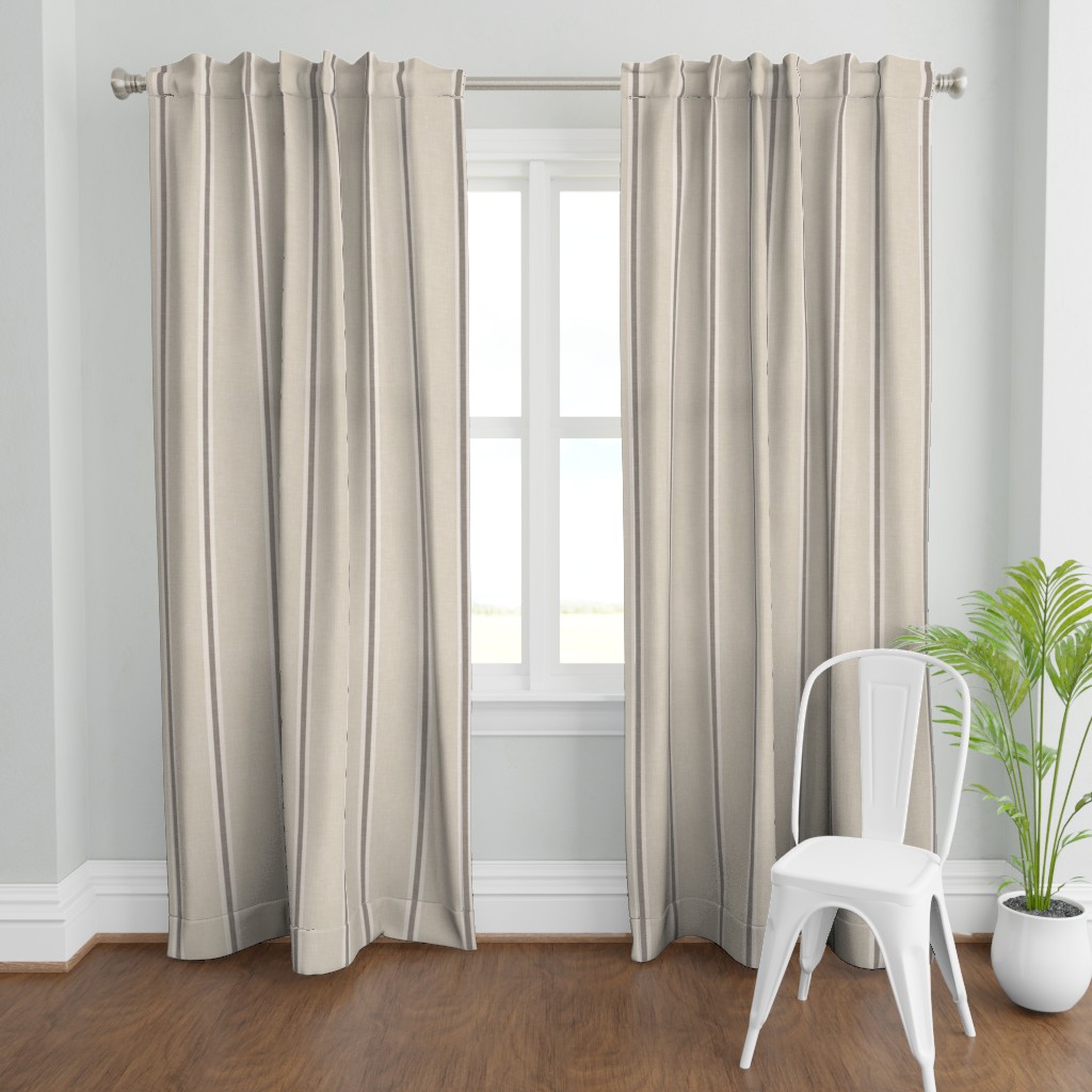 Floor-length curtains featuring the beige Nantucket Linen Textured Stripe design in a light interior with a chair and potted plant.
