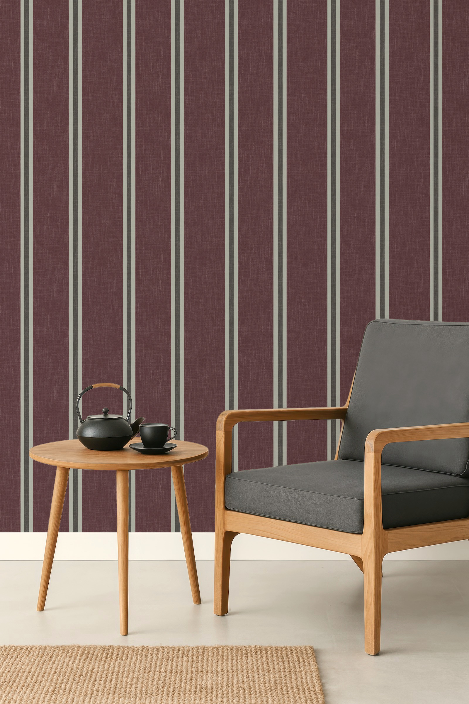 Burgundy Nantucket Linen Textured Stripe wallpaper behind a dark armchair and small wooden side table in a living room setting.