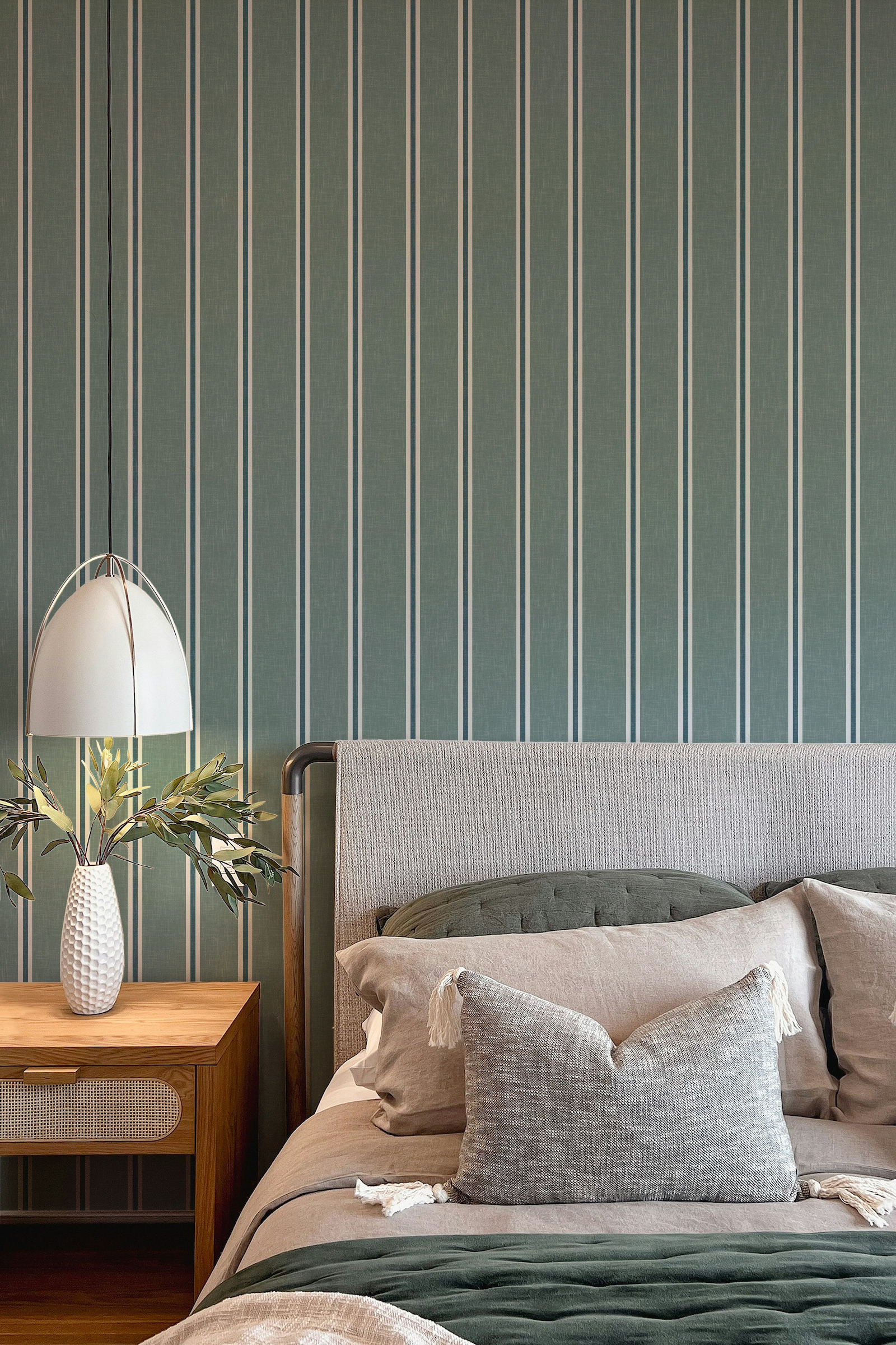 Dark teal Nantucket Linen Textured Stripe wallpaper behind an upholstered bed with dark bedding, pendant light and bedside greenery.
