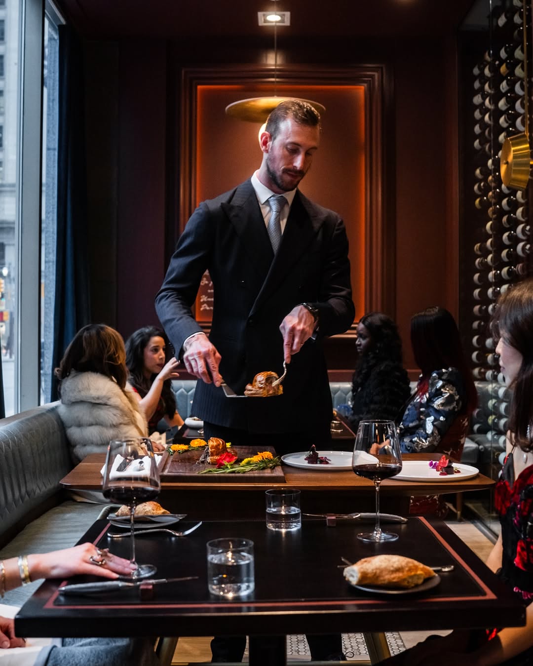 A close-up of a handwritten note on fine ivory paper, resting beside a classic fountain pen and a sprig of winter greenery, all atop a soft grey linen tablecloth. The composition is elegant and personal, evoking care and attention.