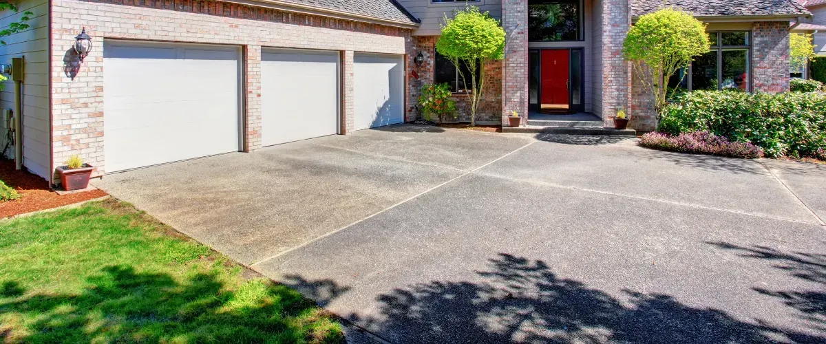 Clean concrete driveway in front of a suburban brick house