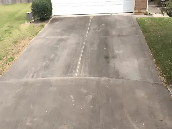 Driveway before pressure washing, showing heavy dirt and grime buildup