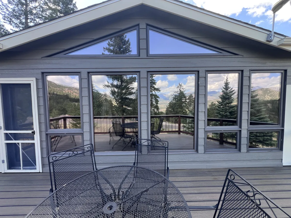 Window tint installed on the gabled sunroom windows of a Colorado mountain cabin