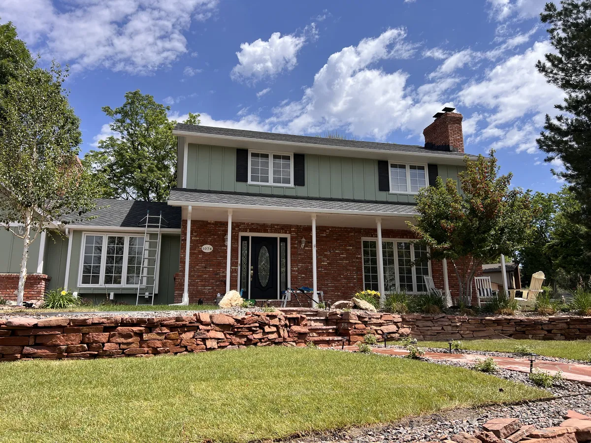Exterior window cleaning on a two-story brick and siding home in Northern Colorado