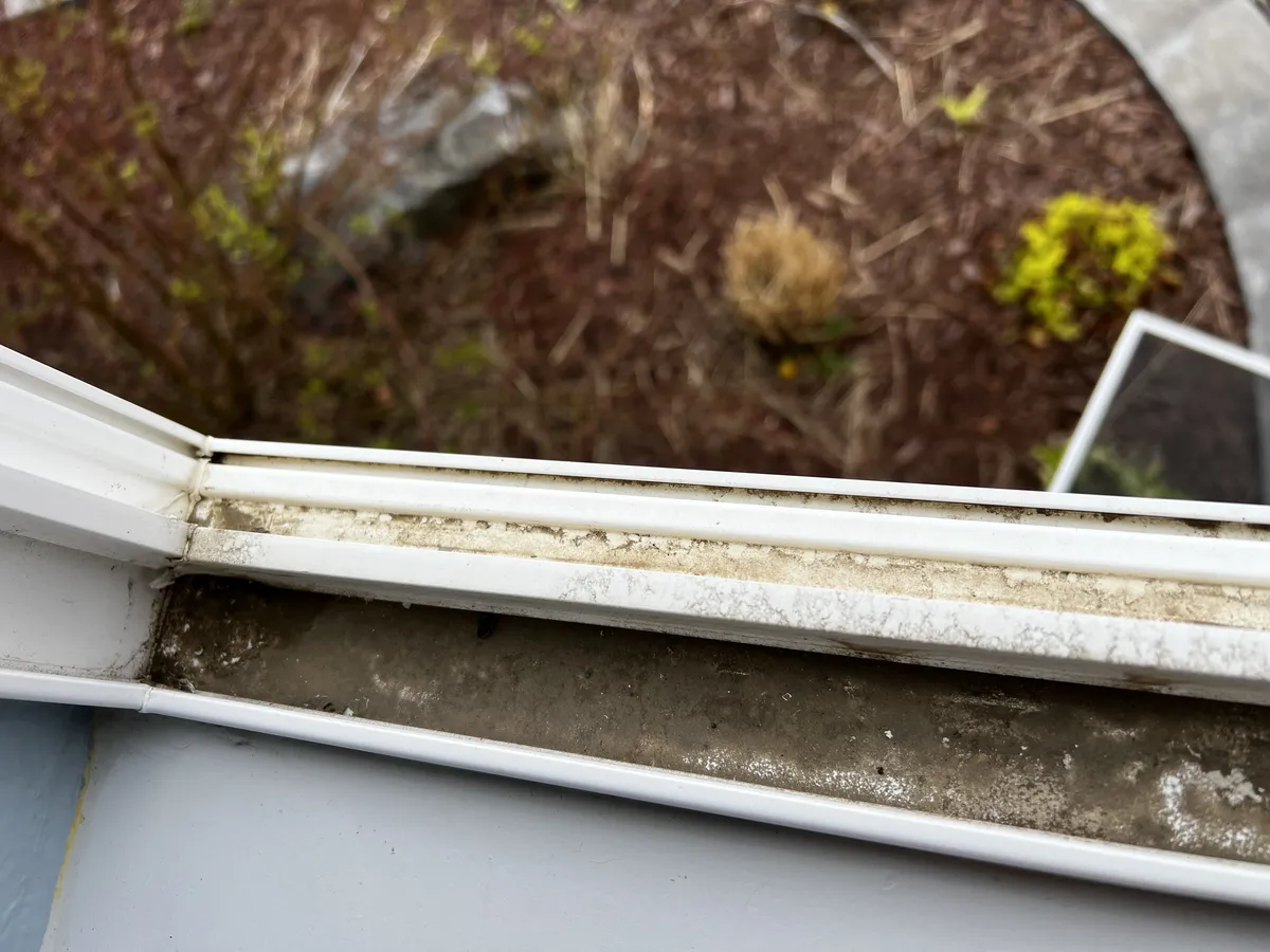 Dirty window tracks with built-up grime before track cleaning