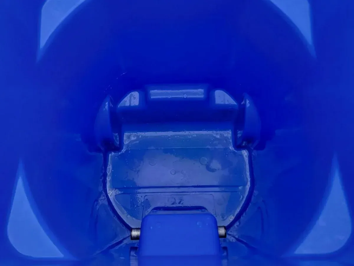 A close-up, downward view into the smooth, curved interior of a vibrant blue plastic container.