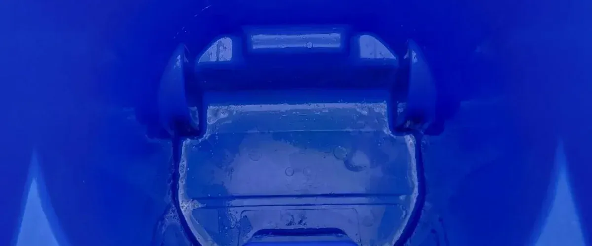 Close-up abstract view of a vibrant blue plastic surface with textured details and water droplets or condensation.