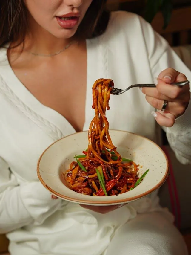 woman eating pasta carbs