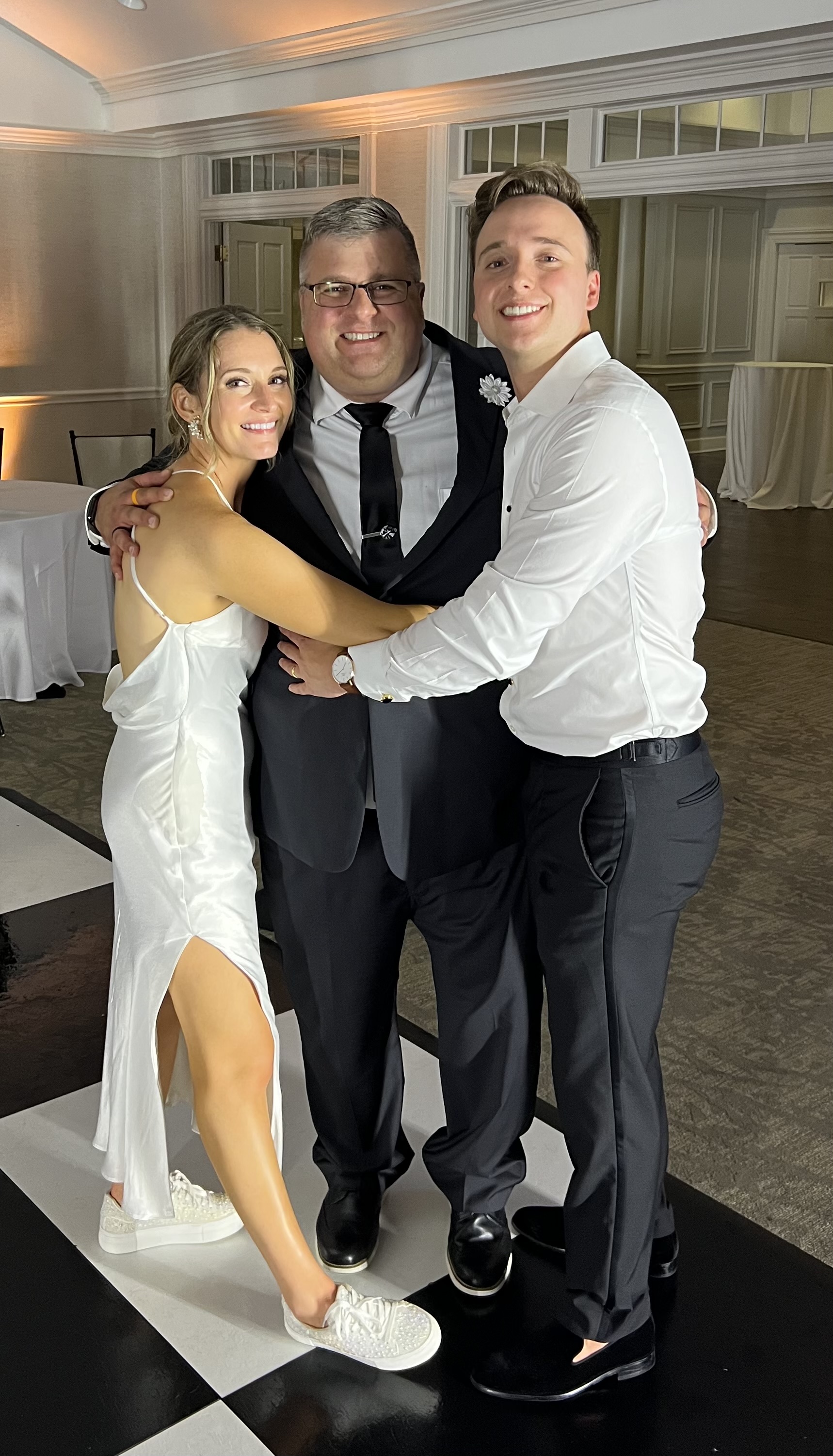 A happy couple posing with DJ Altimate (Alton) at the end of their wedding.