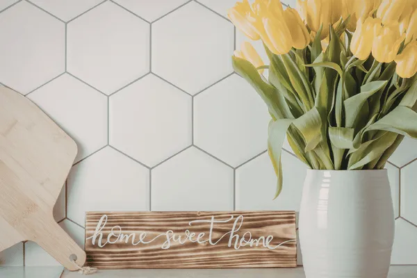 Suds and Spuds Cleaning Co residential client intake form for home resets in Charlottetown Prince Edward Island, featuring an image of vibrant yellow tulips against a clean tiled kitchen backsplash next to a rustic wooden Home Sweet Home sign on a linen white web page canvas