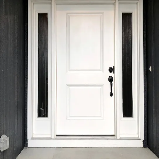 A white UPVC front door with black trim and a black door handle, set against a neutral wall.