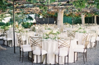 Elegant event venue in Metro Detroit with linen-covered tables, floral centerpieces, and chameleon chairs for weddings and special events