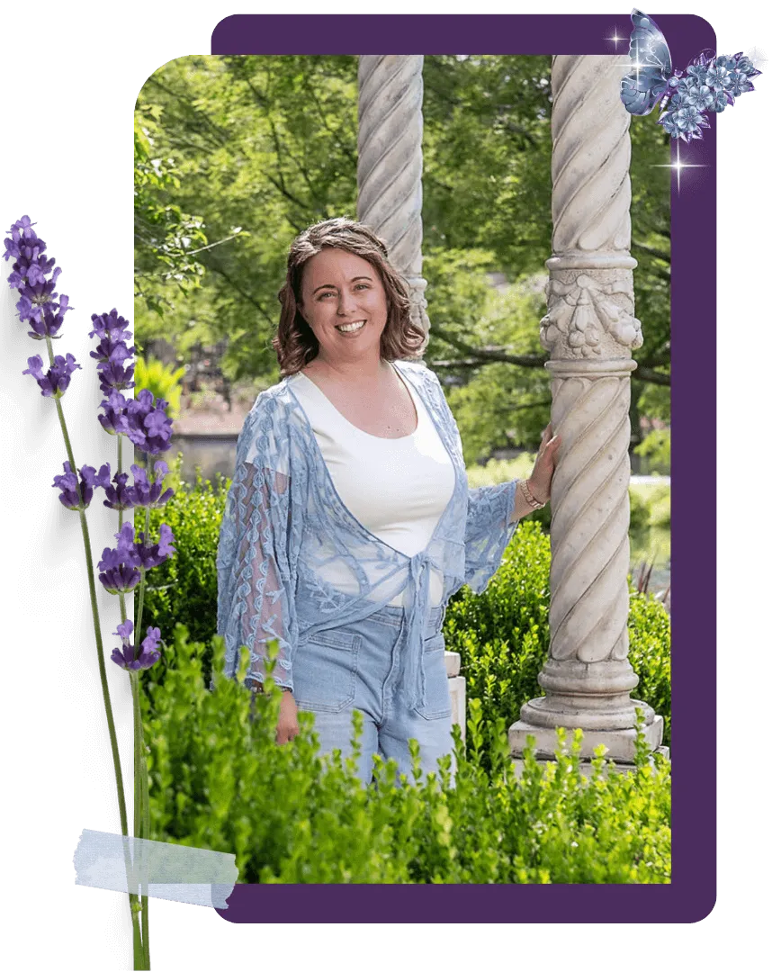 Chelsea Fournier standing between the pillars of a garden gazebo, with lush green foliage in front of her and behind her, wearing a blue shawl over a white t-shirt, and looking helpflul