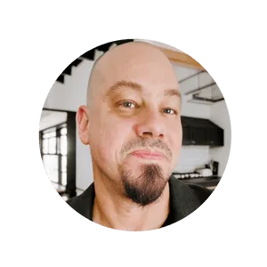 Headshot of Taylor Mesplé with a goatee, standing in a room inside