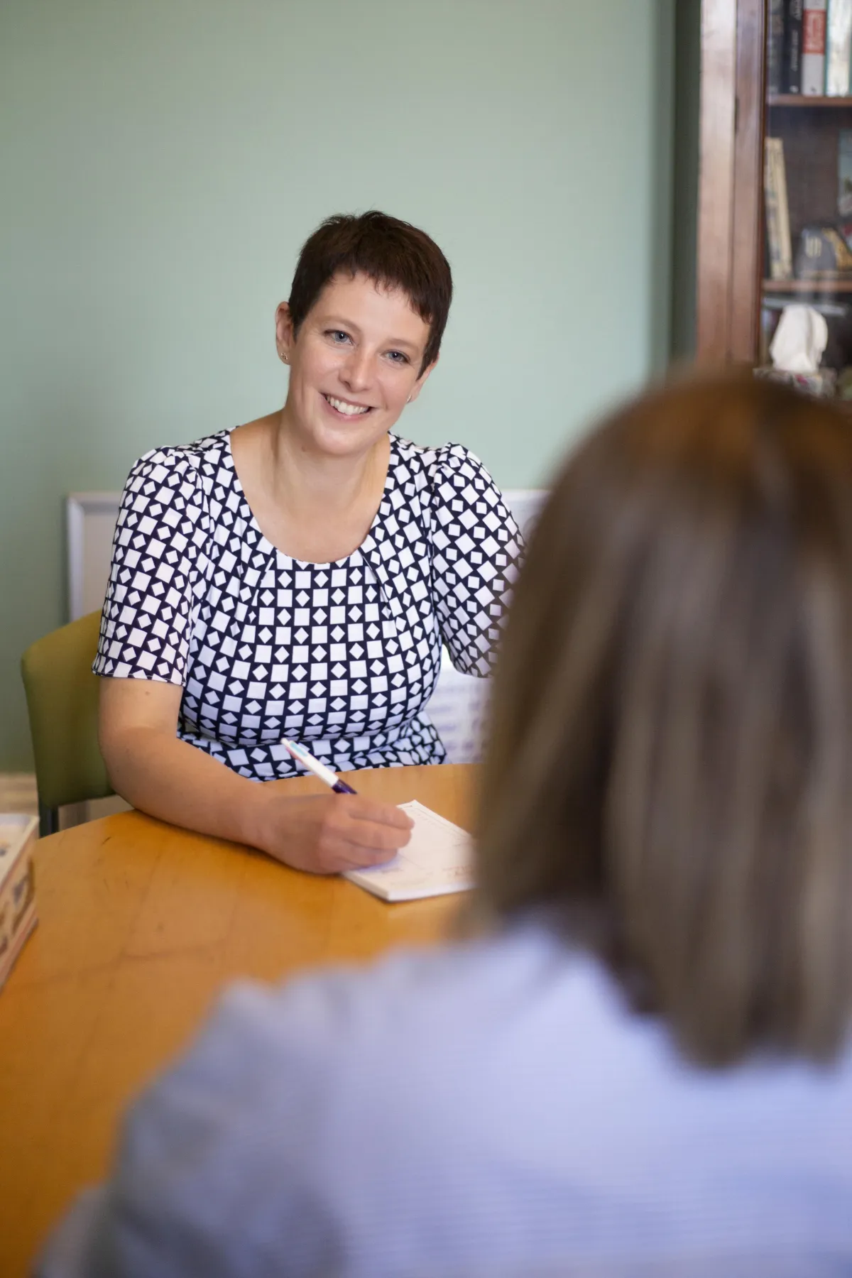 Picture of Charlotte speaking to a female client and taking notes