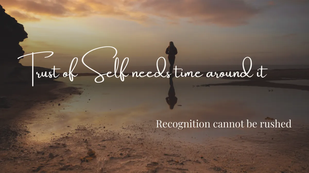 A solitary woman stands on a reflective shoreline at sunrise, gazing toward the horizon as warm golden light spreads across the sky. The image symbolizes self-trust, reflection, personal growth, and the journey of self-discovery through time.