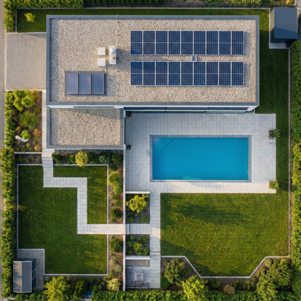 Aerial drone view looking straight down on a residential property with a white-tiled swimming pool, landscaped garden, footpath, and solar panels on the roof.