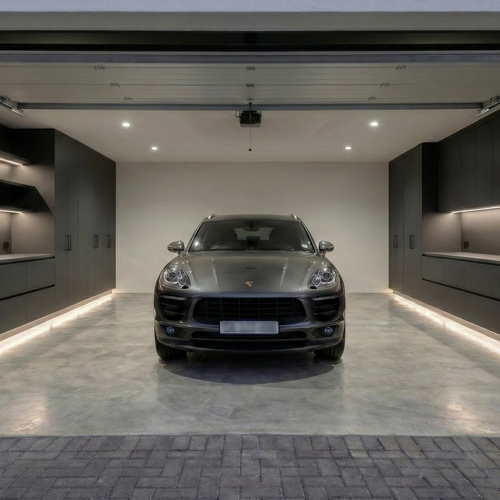 Porsche Macan parked in a modern garage with built-in cupboards on both sides, illuminated by LED lights near the floor and higher up the cabinetry.
