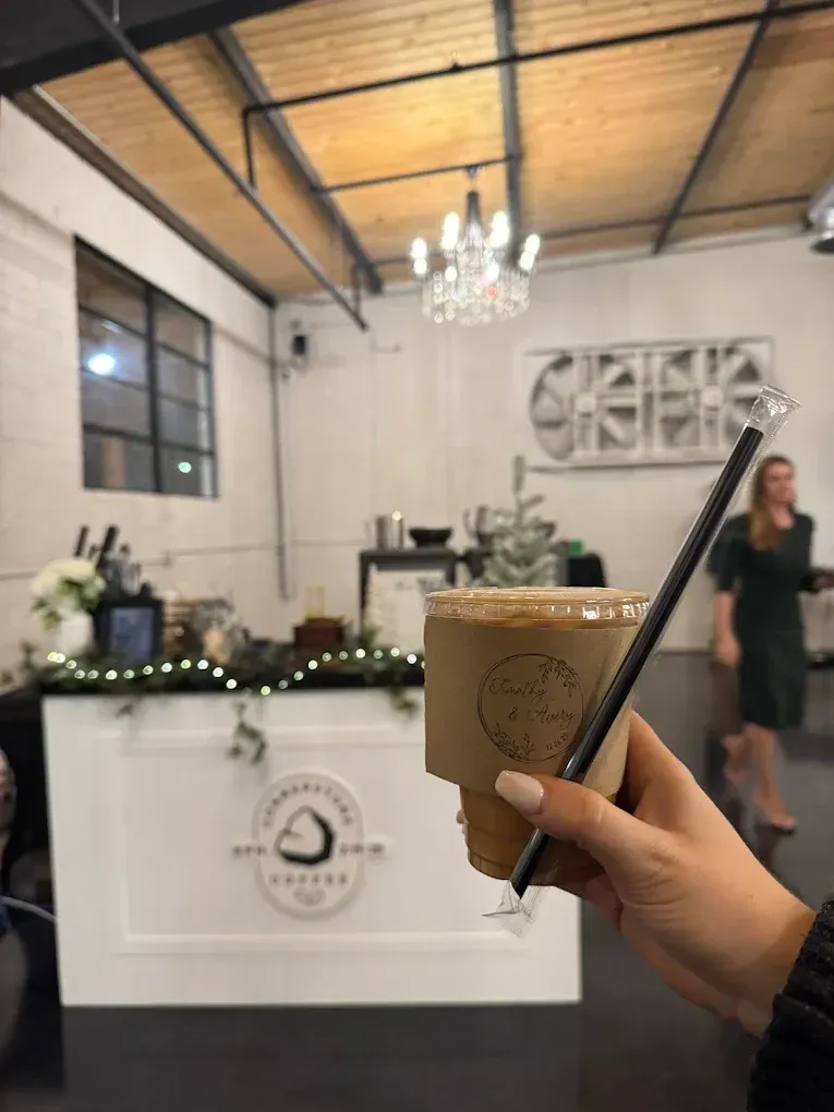 holding a cup of iced coffee