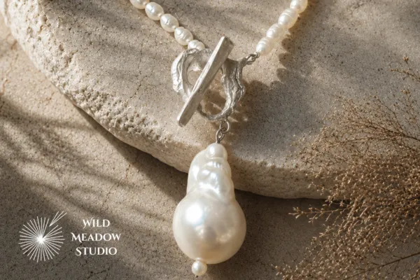 Handmade freshwater pearl necklace with a sculptural fine silver freeform T-bar clasp and baroque pearl pendant by Wild Meadow Studio, created as a bespoke commission."