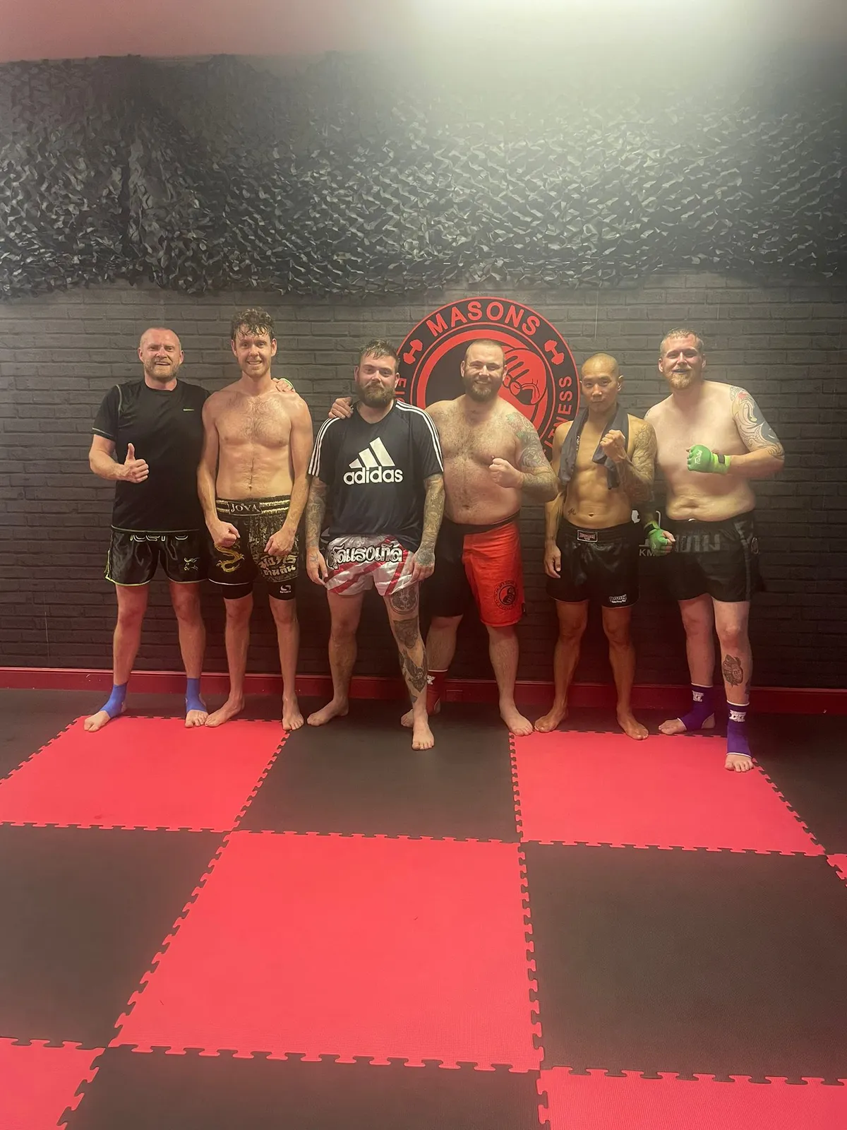 Combat sport founder post-fight victory salute in gym