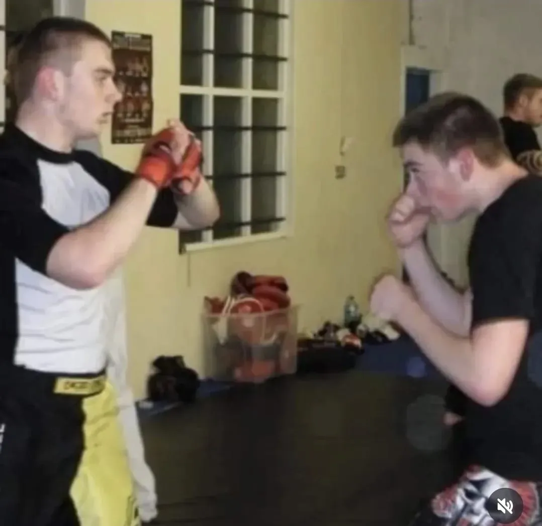 Combat sport founder post-fight victory salute in gym