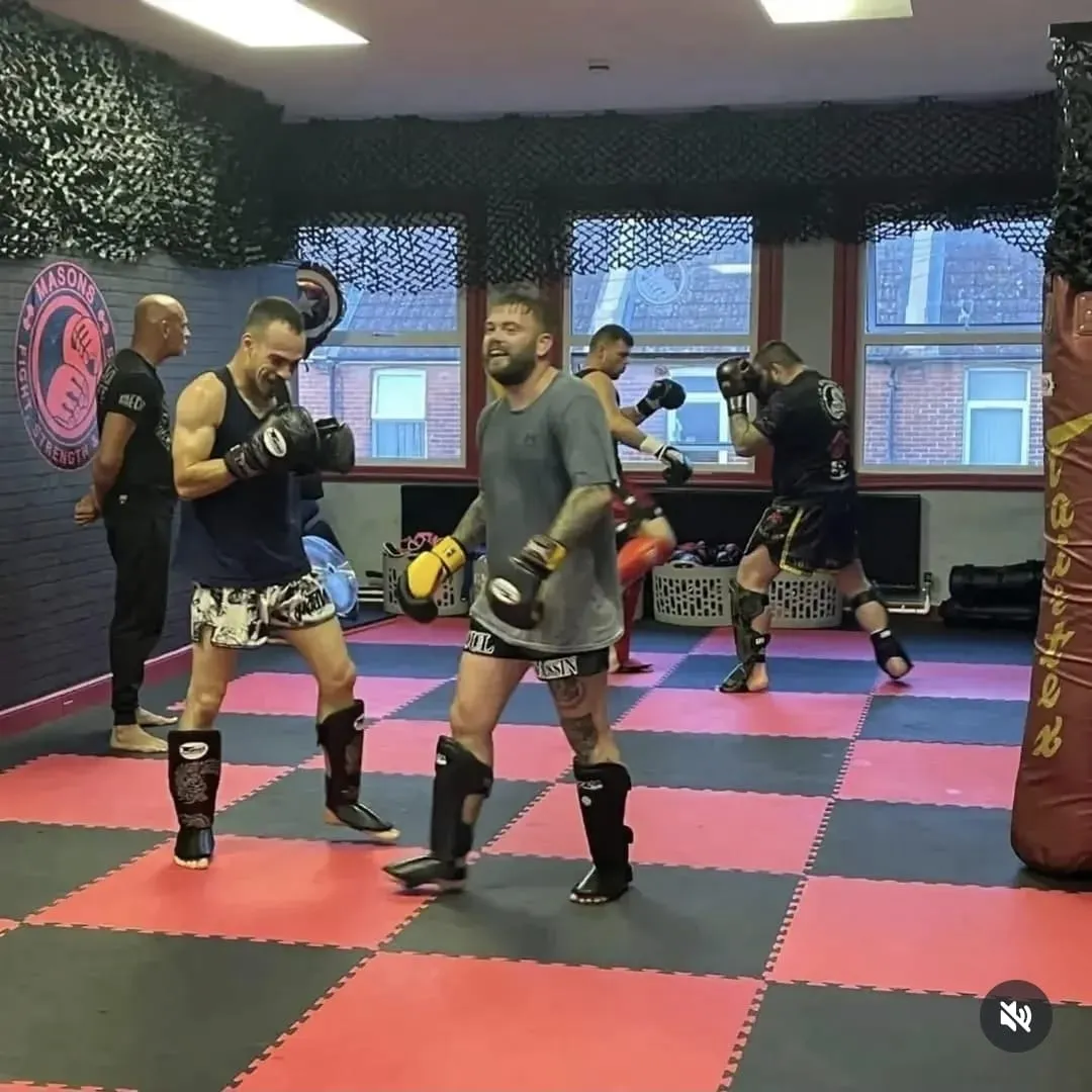 Combat sport founder cage-side coaching in arena