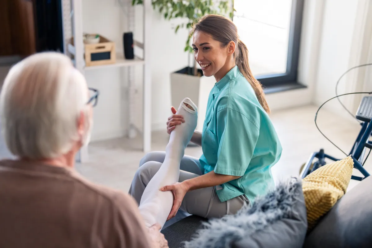 Royal Wound Care home health nurse assisting elderly patient with orthopedic cast care, specializing in mobile wound care and pressure injury prevention.