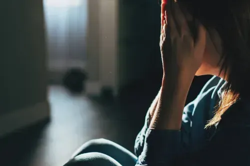 Honor & Clarity Coaching Ministry - Bill & Rebecca Alderman - Image of a woman sitting on the floor in a dark room covering her face with her hands, distraught.