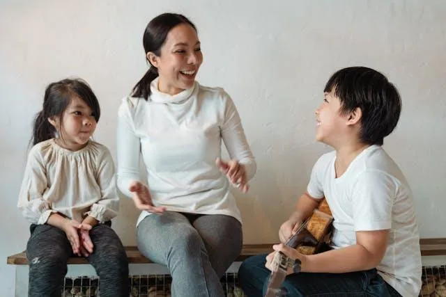 Mom, daughter, and son playing guitar