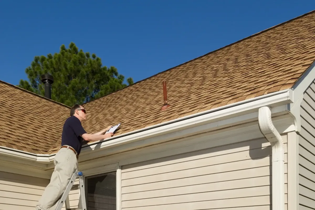 Roof inspector reviewing damage with clipboard