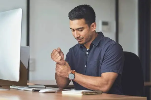 A man holding his wrist because of carpal tunnel pain