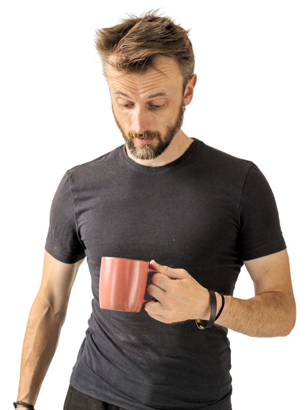 Transformation coach and author Anthony Punshon wearing a fitted crew-neck t-shirt and holding a tea mug while looking down thoughtfully.