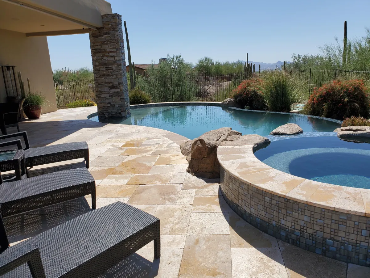 "Crystal-clear pool reflecting the Arizona desert sky, surrounded by stunning cacti and warm, sunlit scenery."