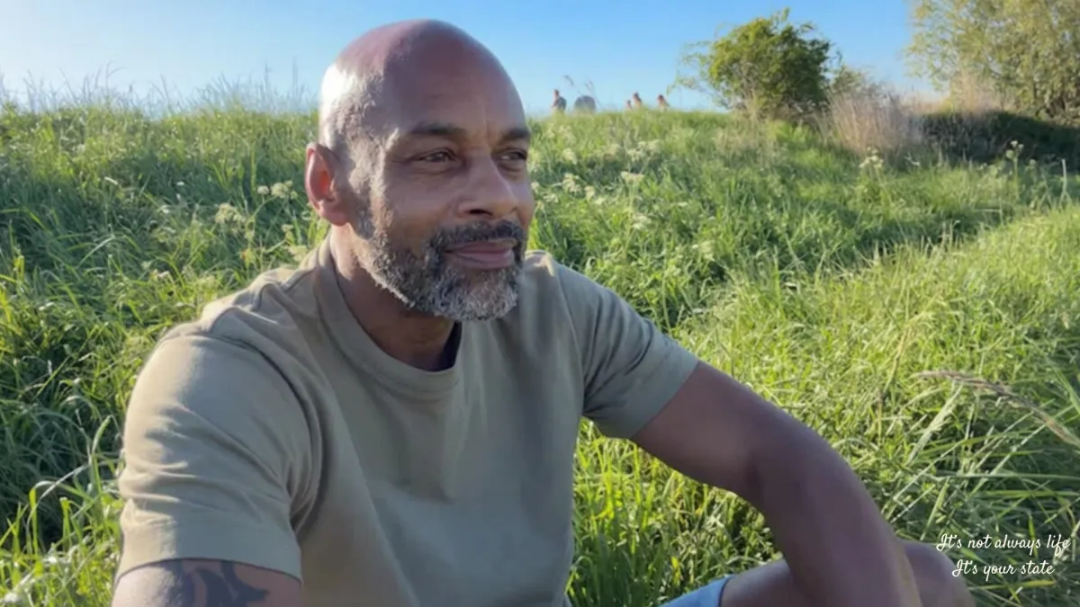 Person sitting quietly in nature reflecting on emotional heaviness, awareness, and how internal states shape the experience of life.
