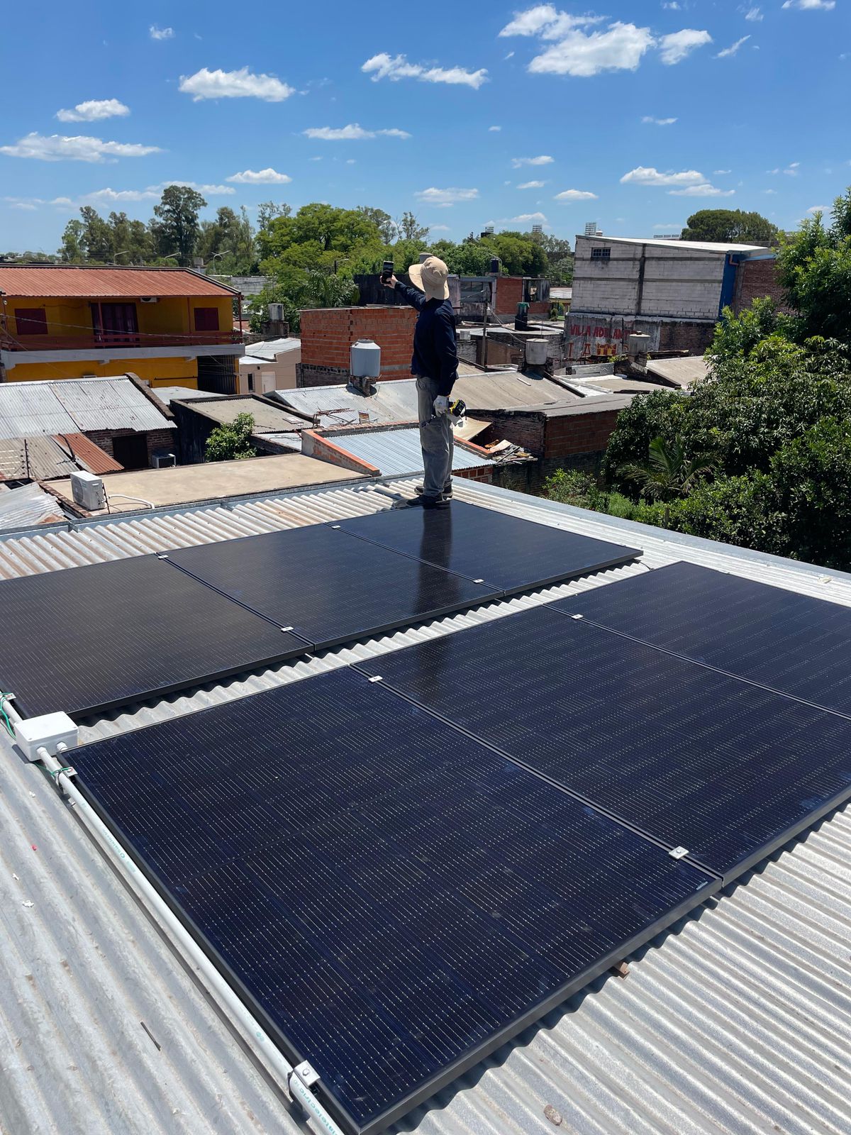 Paneles solares en techo de casa familiar en Resistencia, Chaco, día soleado, niños jugando en el jardín